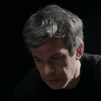 A Close Up Of A Man 'S Face In A Dark Room GIF