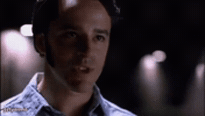 A Close Up Of A Man 'S Face In A Dark Room With A Blurred Background . GIF