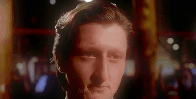A Close Up Of A Man 'S Face In A Dark Room With A Blurred Background GIF