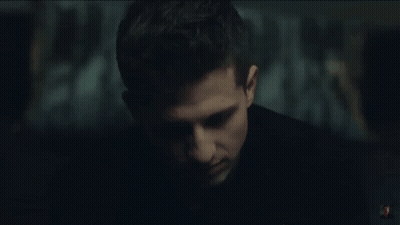 A Close Up Of A Man 'S Face In A Dark Room With A Blurry Background . GIF