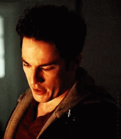A Close Up Of A Man 'S Face In A Dark Room With A Hoodie On GIF