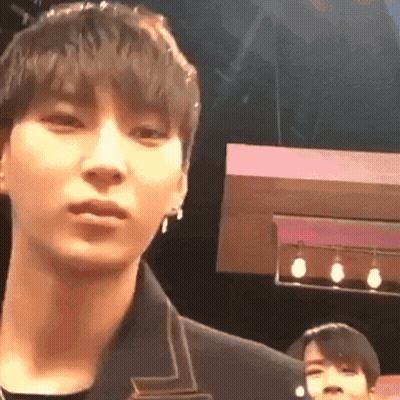A Close Up Of A Man 'S Face In A Dark Room With A Pink Background . GIF