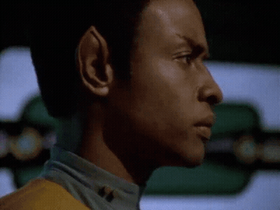 A Close Up Of A Man 'S Face In A Dark Room With A Yellow Shirt On . GIF