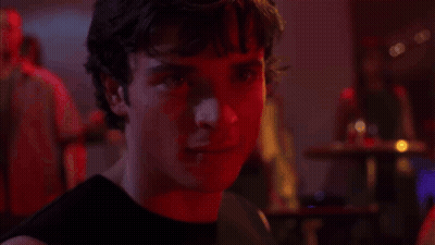 A Close Up Of A Man 'S Face In A Dark Room With Red Lights Behind Him . GIF