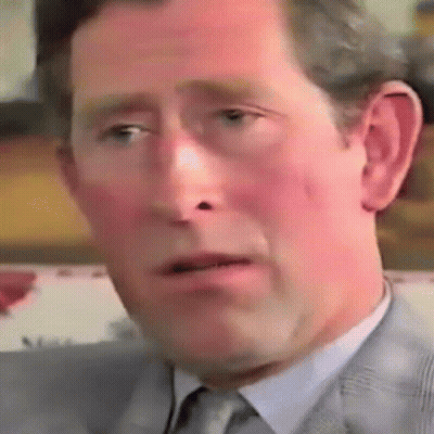 A Close Up Of A Man 'S Face In A Suit And Tie Making A Funny Face . GIF