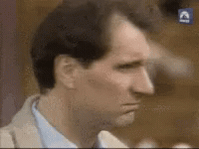 A Close Up Of A Man 'S Face In A Suit And Tie . GIF
