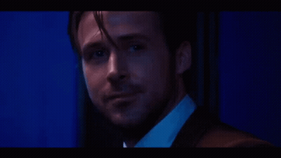 A Close Up Of A Man 'S Face In A Suit And White Shirt In A Dark Room . GIF