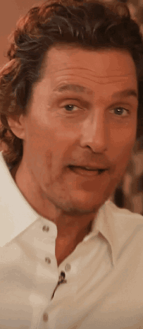 A Close Up Of A Man 'S Face In A White Shirt With A Microphone . GIF