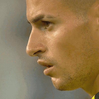 A Close Up Of A Man 'S Face In A Yellow And Black Shirt GIF