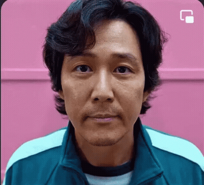 A Close Up Of A Man 'S Face In Front Of A Pink Wall . GIF