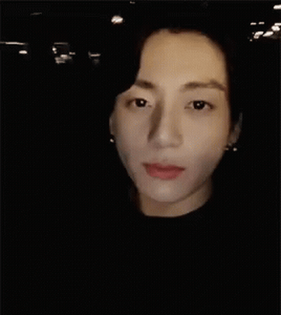 A Close Up Of A Man 'S Face In The Dark GIF