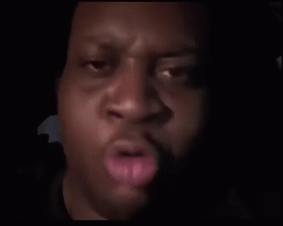 A Close Up Of A Man 'S Face In The Dark With A Blurred Background . GIF