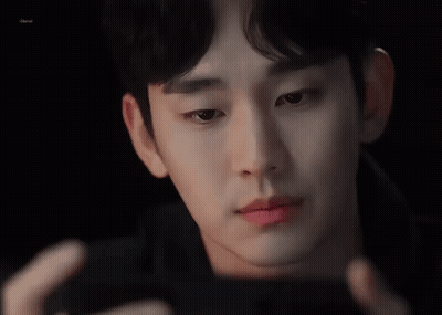 A Close Up Of A Man 'S Face Looking At A Cell Phone . GIF