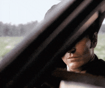 A Close Up Of A Man 'S Face Looking Out A Car Window GIF