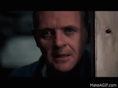 A Close Up Of A Man 'S Face Looking Out A Door . GIF