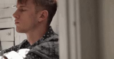 A Close Up Of A Man 'S Face Looking Out A Window GIF
