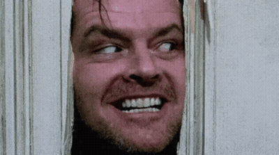 A Close Up Of A Man 'S Face Looking Through A Hole In A Wall . GIF