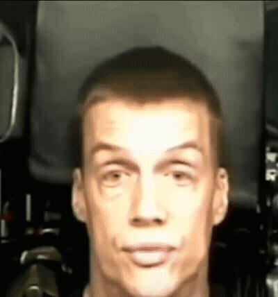 A Close Up Of A Man 'S Face Making A Funny Face In A Dark Room . GIF