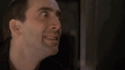 A Close Up Of A Man 'S Face Making A Funny Face In A Dark Room . GIF