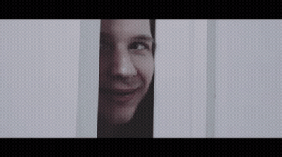 A Close Up Of A Man 'S Face Peeking Out Of A Door . GIF