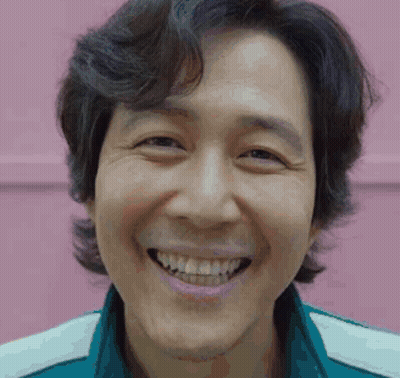 A Close Up Of A Man 'S Face Smiling Against A Pink Background . GIF