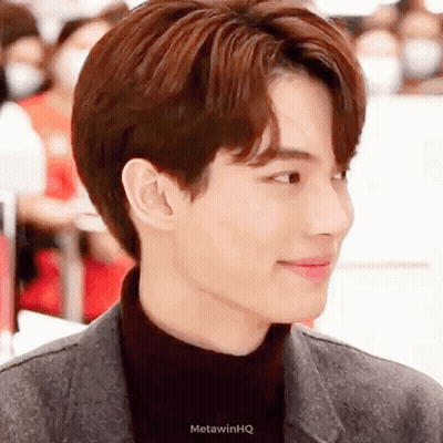 A Close Up Of A Man 'S Face Wearing A Black Turtleneck And A Jacket . GIF
