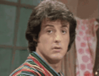 A Close Up Of A Man 'S Face Wearing A Colorful Shirt . GIF