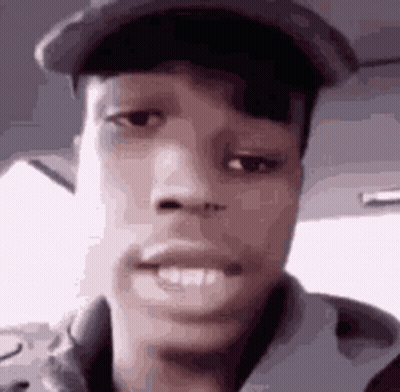 A Close Up Of A Man 'S Face Wearing A Hat And A Jacket . GIF