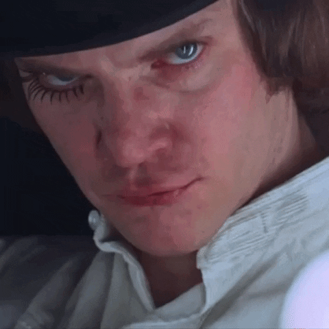 A Close Up Of A Man 'S Face Wearing A Hat And A White Shirt . GIF