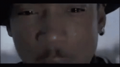 A Close Up Of A Man 'S Face Wearing A Hat And Earring . GIF