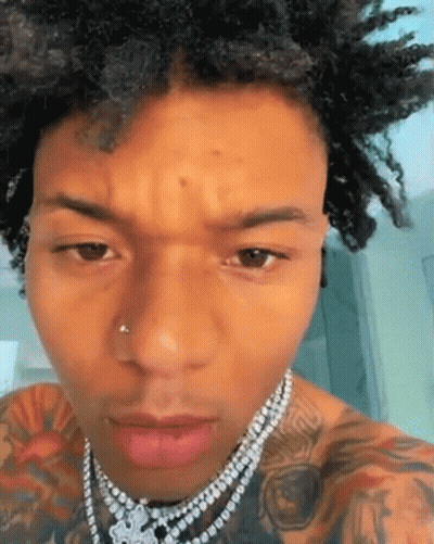 A Close Up Of A Man 'S Face Wearing A Necklace . GIF