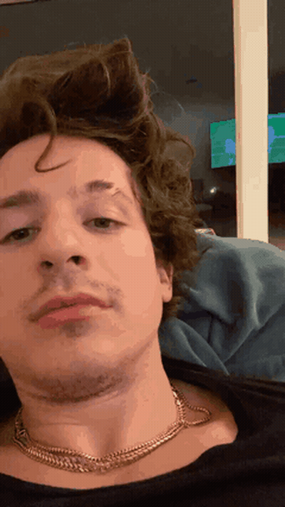 A Close Up Of A Man 'S Face Wearing A Necklace GIF