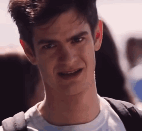 A Close Up Of A Man 'S Face With A Backpack Behind Him GIF