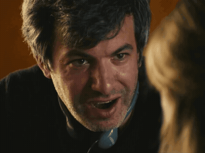 A Close Up Of A Man 'S Face With A Beard And A Phone That Says ' Siemens ' On The Side GIF