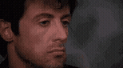 A Close Up Of A Man 'S Face With A Beard And A Red Nose . GIF