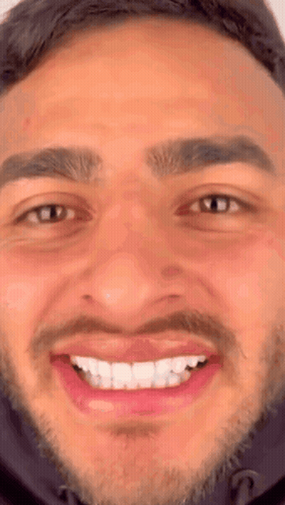 A Close Up Of A Man 'S Face With A Beard And A Smile On His Face . GIF