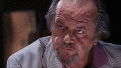 A Close Up Of A Man 'S Face With A Beard And A Striped Shirt GIF