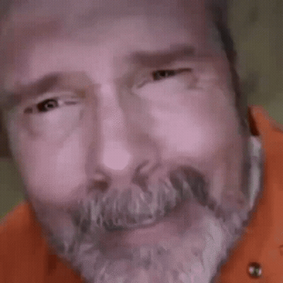 A Close Up Of A Man 'S Face With A Beard And Big Eyes Looking At The Camera . GIF