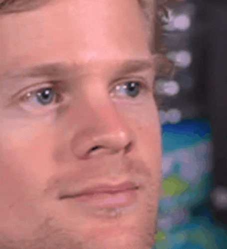 A Close Up Of A Man 'S Face With A Beard And Blue Eyes Looking At The Camera . GIF