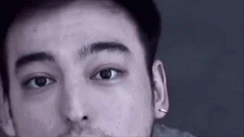 A Close Up Of A Man 'S Face With A Beard And Piercings In His Ears . GIF