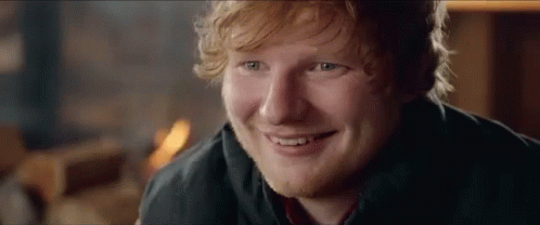 A Close Up Of A Man 'S Face With A Beard And Red Hair Smiling . GIF