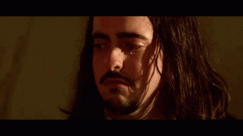 A Close Up Of A Man 'S Face With A Beard In A Suit And Tie . GIF