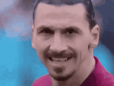 A Close Up Of A Man 'S Face With A Beard Smiling . GIF