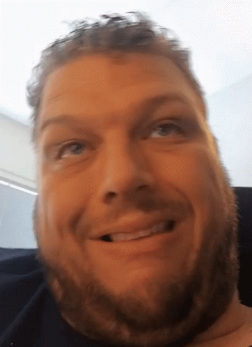 A Close Up Of A Man 'S Face With A Beard Smiling GIF