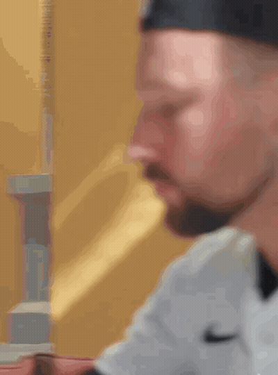 A Close Up Of A Man 'S Face With A Beard Wearing A Nike Shirt GIF
