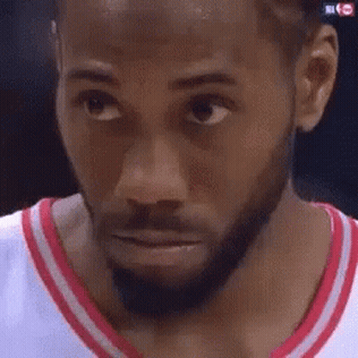 A Close Up Of A Man 'S Face With A Beard Wearing A Red And White Shirt . GIF