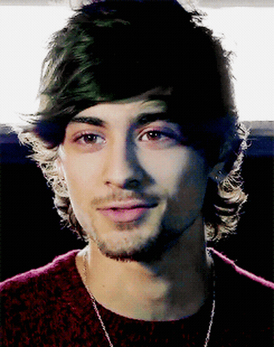A Close Up Of A Man 'S Face With A Beard Wearing A Red Sweater GIF