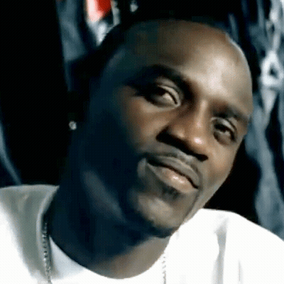 A Close Up Of A Man 'S Face With A Beard Wearing A White Shirt And A Necklace . GIF