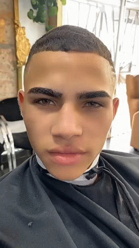 A Close Up Of A Man 'S Face With A Black Cape On GIF