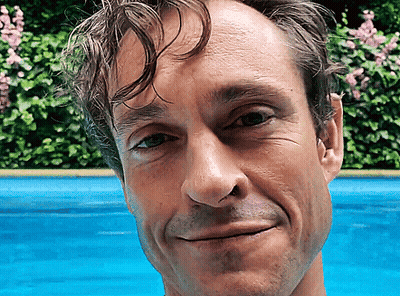 A Close Up Of A Man 'S Face With A Blue Background GIF